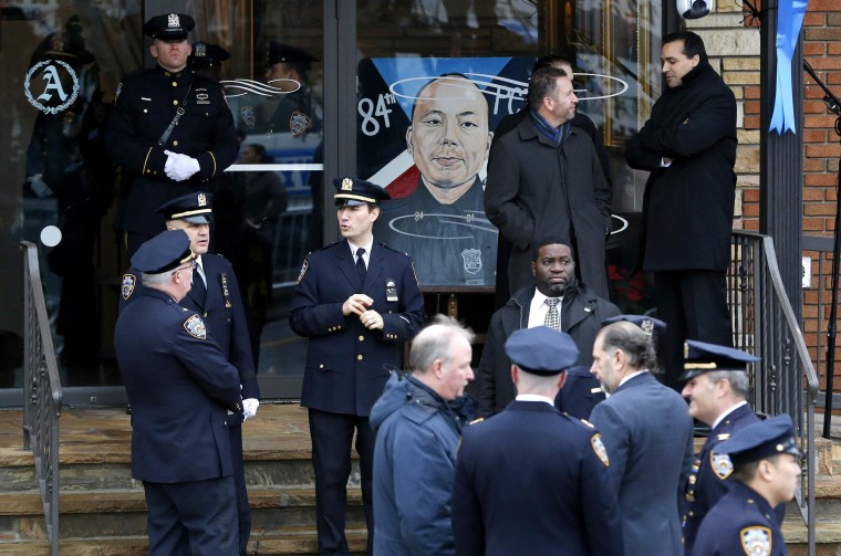 Image: A painting with the likeness of New York City police officer Wenjian Liu is displayed prior to funeral services for him at Aievoli Funeral Home