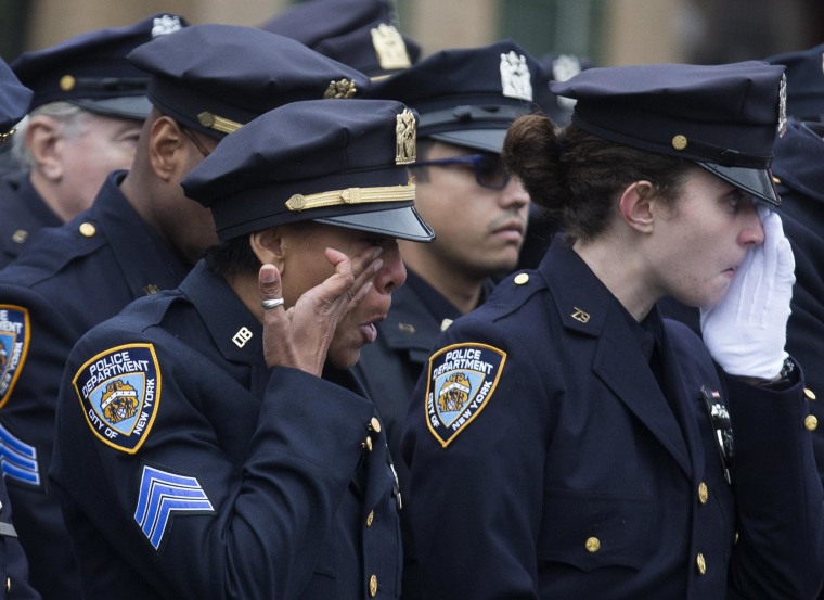 Image: Police officers wipe their tears during the funeral of New York Police Department Officer Wenjian Liu