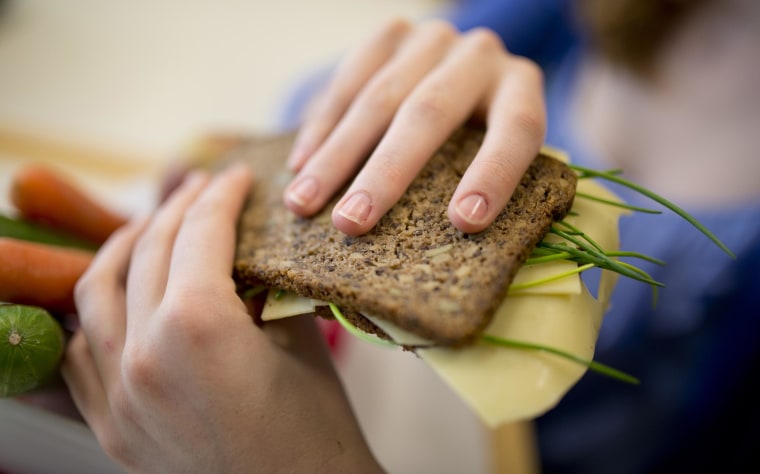 Image:  Student with a healthy breakfast, lunchbox filled with wholewheat bread, fruit and vegetables.