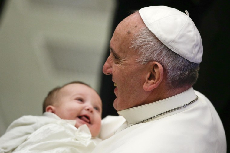 Image: Pope Francis holds a baby during his weekly general audience in Paul VI hall at the Vatican