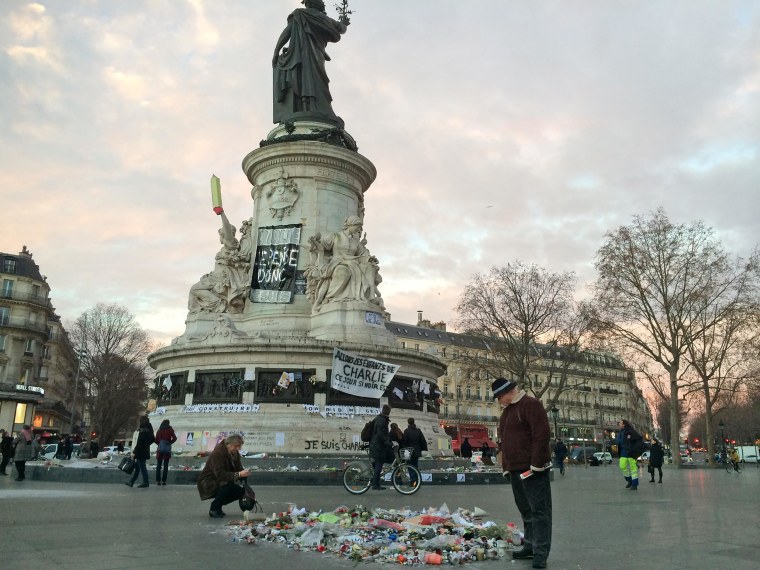 Tributes to the recent terrorist attacks adorn Place de la Republique early on Jan. 13 in Paris.