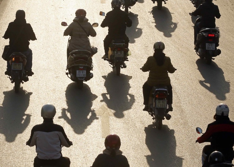 Image: Motorcyclists ride on a street in Hanoi