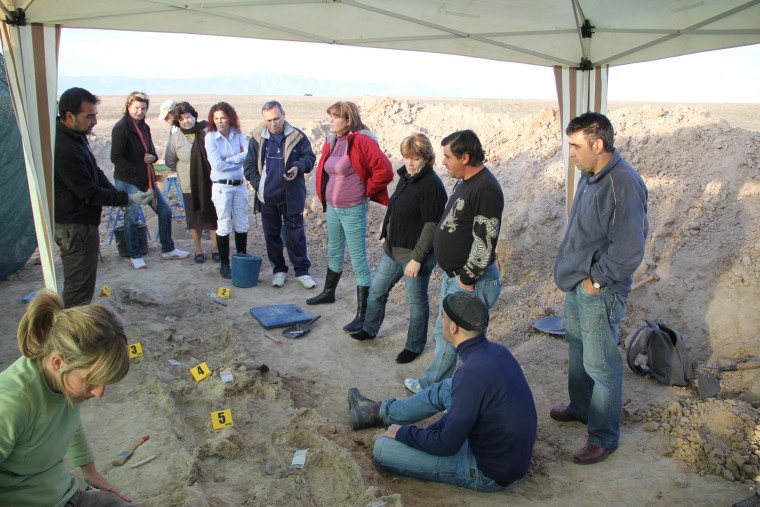 Image: A group assembles during a 2010 excavation and subsequent exhumation of 7 people who were shot and killed in a fusilade on November 1936 during Spain's Civil War.