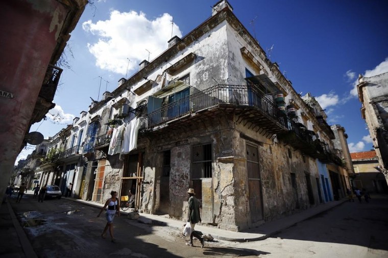 Pedestrians pass crumbling buildings in Old Havana.