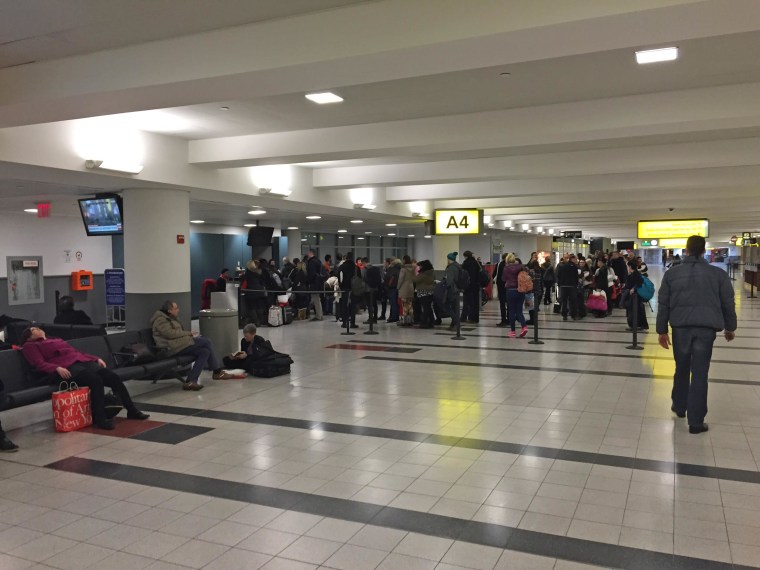 Travelers wait at JFK airport early Tuesday, Jan. 27 after a Virgin Atlantic flight was cancelled after six hours on the tarmac.