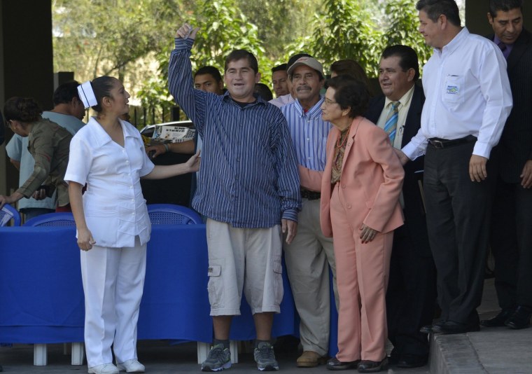Image: Castaway fisherman Alvarenga  waves next to a nurse and El Salvador's Health Minister Rodriguez while leaving the hospital in Santa Tecla