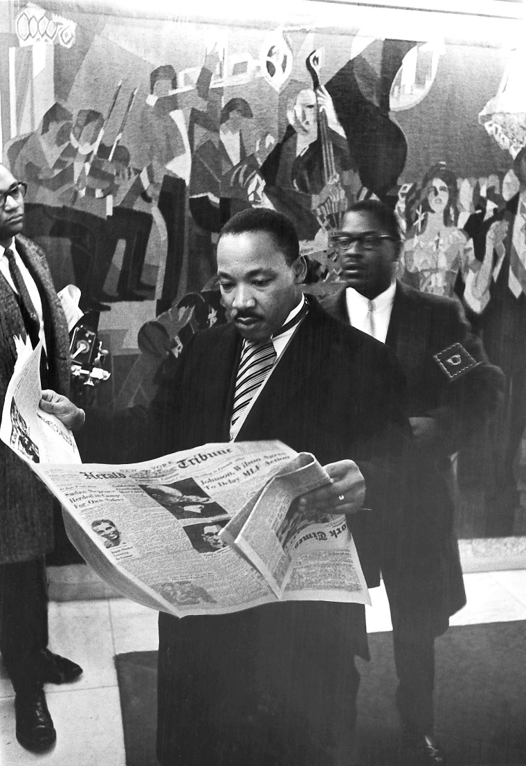 Image: Martin Luther King Jr. Reads the newspaper as he prepares to  accept his Nobel Prize Award in 1964 in this handout image