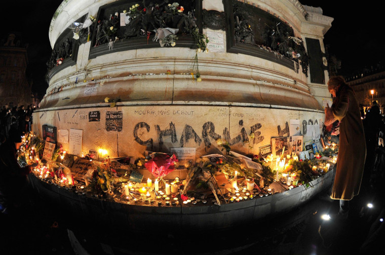 Image: People gather to light candles at Place de la Republique