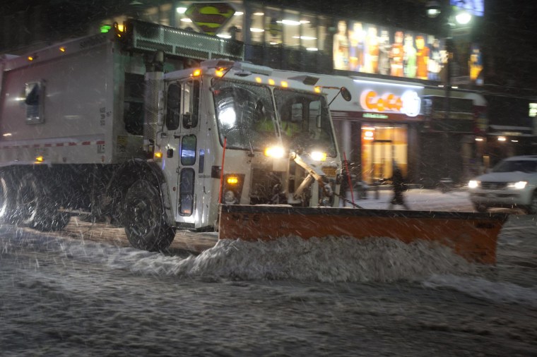 A snow plow clears the road down Lexington Avenue near Grand Central Terminal as it snows in the Manhattan borough of New York Jan. 26, 2015. 