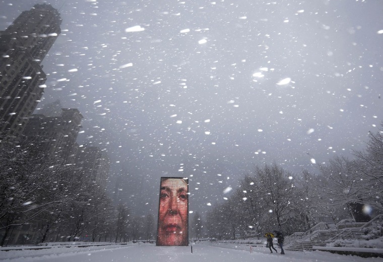 Two men walk past the Crown Fountain in blizzard conditions in Chicago, Illinois February 1, 2015. 