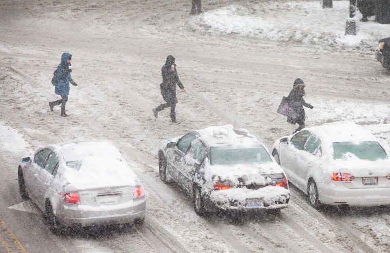 Image: Pedestrian and motorists navigate a snow-covered street in Chicago