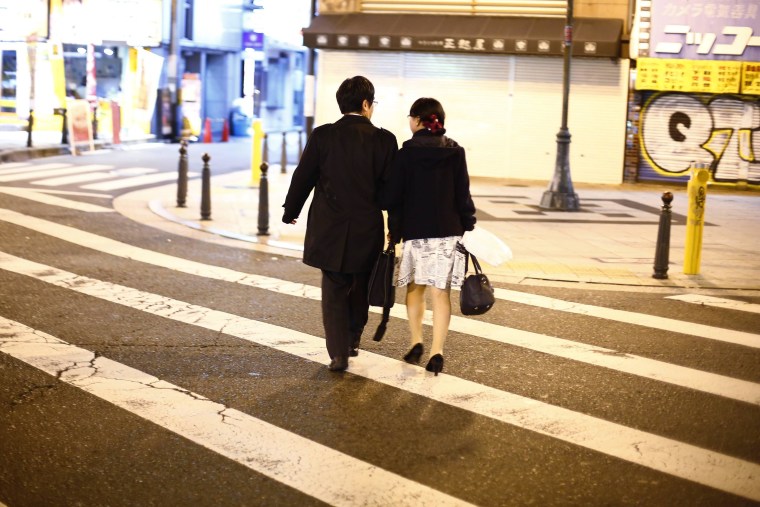 Image: Couple cross street in amusement district of Osaka
