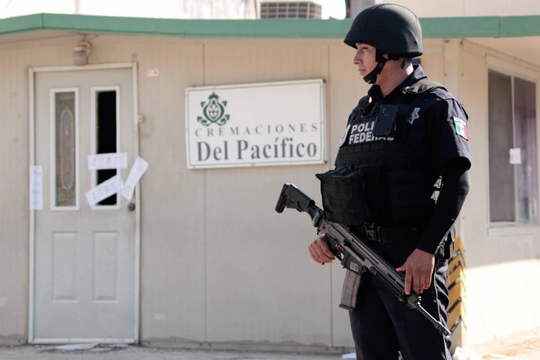 Image: Federal Police personnel stand guard outside a private crematorium where at least 61 corpses in an advanced state of decomposition were found in Acapulco, Guerrero State