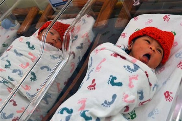 Newborns in their red knitted caps.