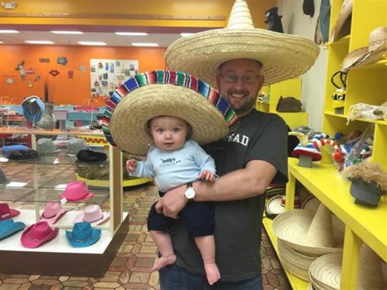 Carrie Burke's husband poses with their baby.