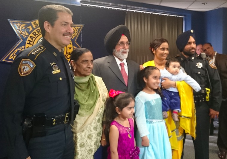 Deputy Sandeep Singh Dhaliwal with family and Sheriff Adrian Garcia (R-L).