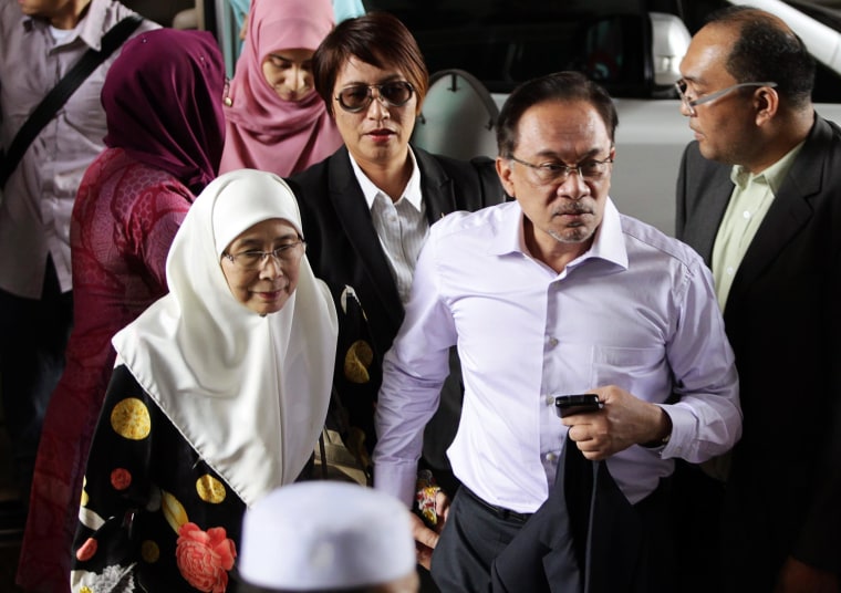 Image: Malaysia's opposition leader Anwar Ibrahim arrives with his wife Wan Azizah, for the verdict in his final appeal against a conviction for sodomy, at the federal court in Putrajaya