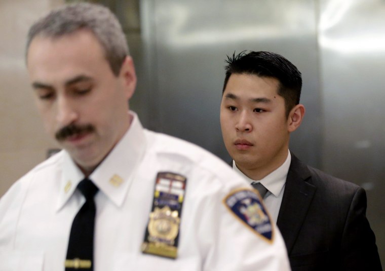 Image: New York City Police (NYPD) officer Peter Liang (R) is escorted by a court officer inside the criminal court after an arraignment hearing in the Brooklyn borough of New York City