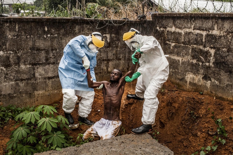 Image: Medical staff at the Hastings Ebola Treatment Center work to escort a man in the throes of Ebola-induced delirium 