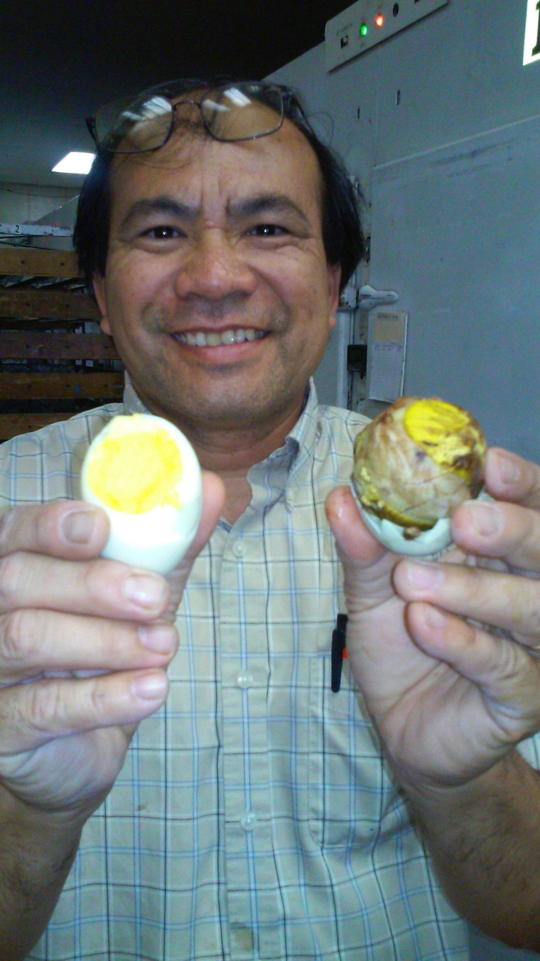 Thomas Chin Dam shows the difference between a fresh and a fertilized duck egg.