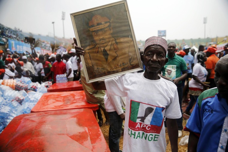 Image: A supporter holds a framed portrait of Muhammadu Buhari