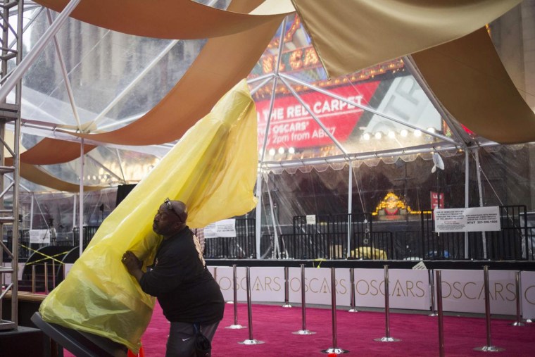 Image: A man moves an Oscar statue along the red carpet outside the Dolby Theatre in Hollywood, hours before arrivals for the Academy Awards in Los Angeles, California