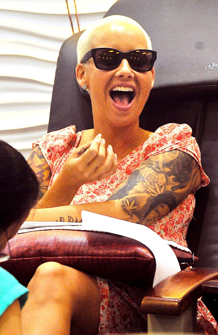 EXCLUSIVE: Amber Rose gets a manicure while texting, then bumps into Iggy Azalea on her way out of the Nail Salon in Los Angeles, CA