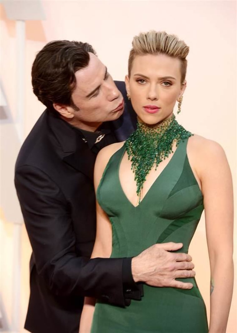 John Travolta gives Scarlett Johansson an unexpected greeting as they arrive at the 87th annual Academy Awards.