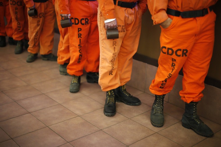Image: Prison inmates wearing firefighting boots line up for breakfast at Oak Glen Conservation Fire Camp #35 in Yucaipa