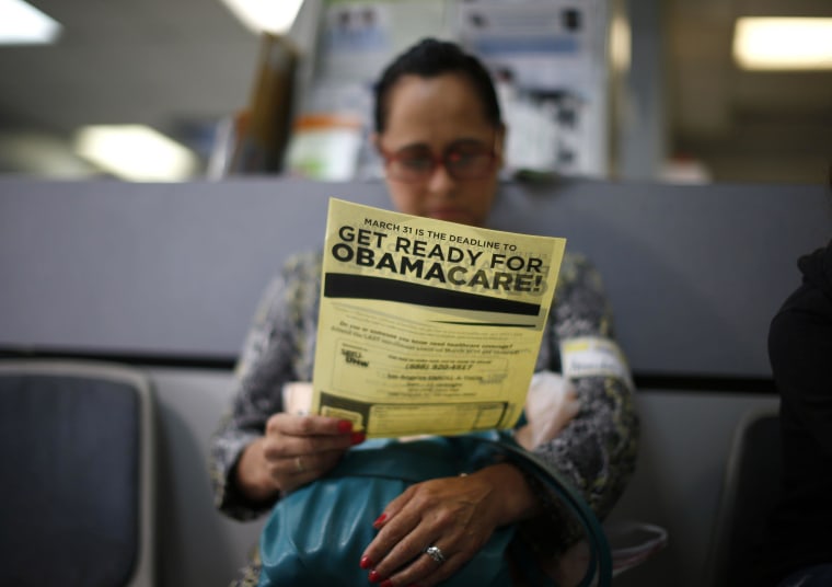 Image: Murillo reads a leaflet at a health insurance enrollment event in Cudahy, California