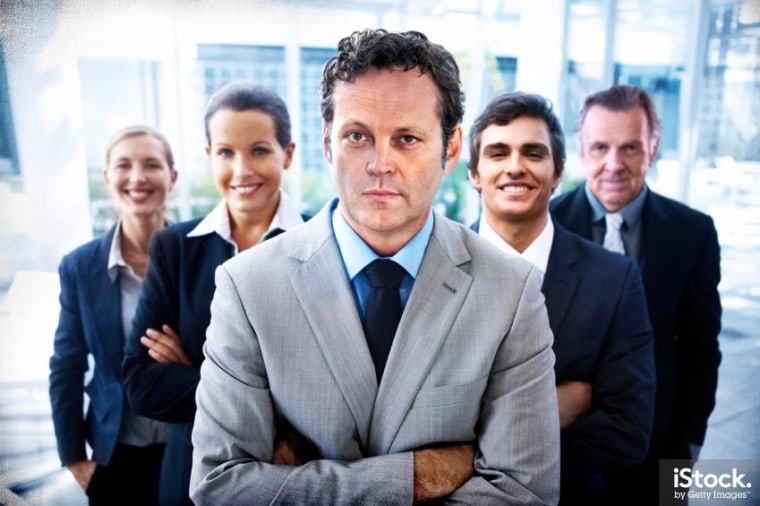 To promote the new movie "Unfinished Business," Vince Vaughn and other members of the cast posed for stock photos. This one is captioned, "Portrait of a handsome business leader crossing his arms with his team standing behind him."