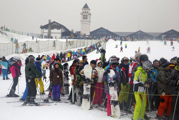 Image: Skiers and snow boarders line up as they take to the slopes of Nanshan ski resort