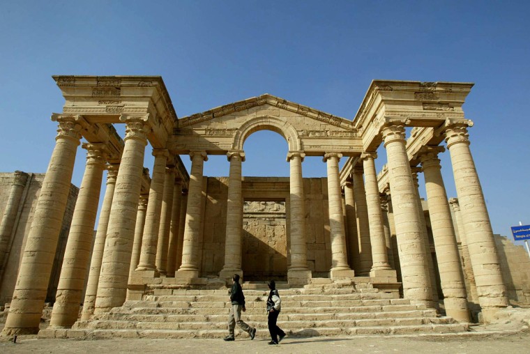 Image: Iraqi children run in front of a temple in the historic city of Hatra in 2002