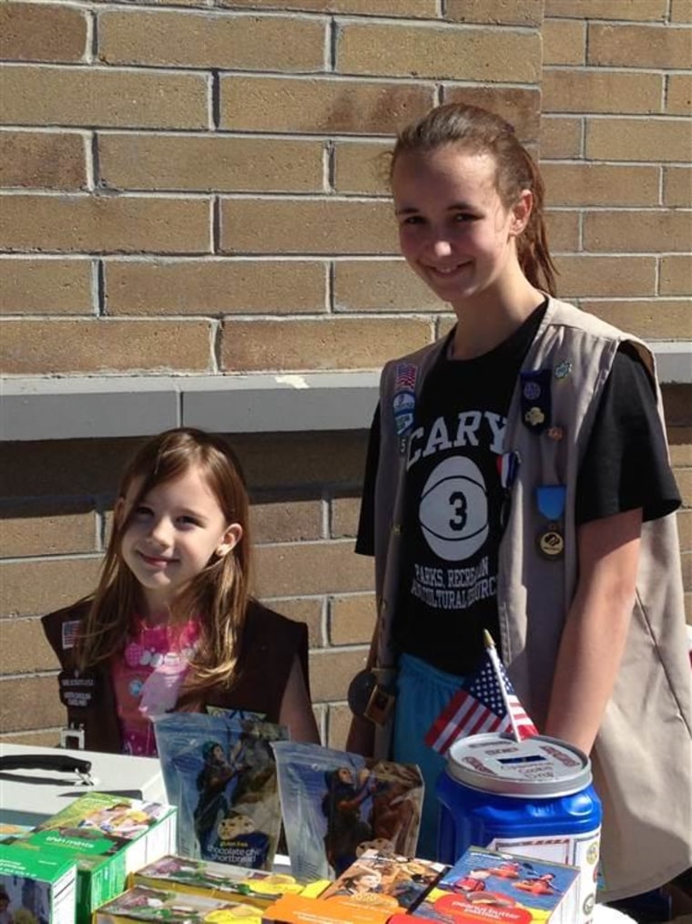 Haley Gray's daughters, Xena and Elizabeth, selling Girl Scout cookies outside of a local business.