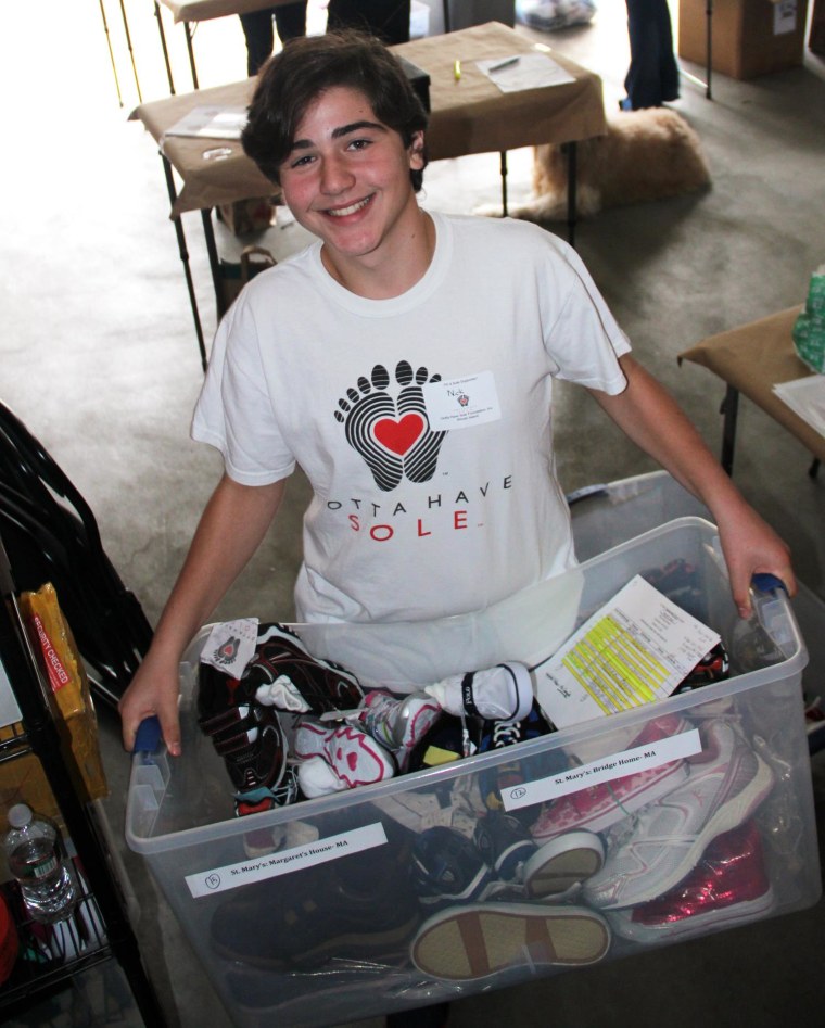 Nicholas Lowinger shows shoes donated to his charity, Gotta Have Sole.