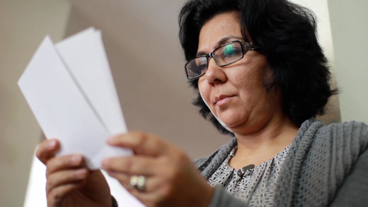 Fauzia Din holds a picture of her husband Berashk, who has been denied a visa to America under a broad and vague anti-terrorism law.