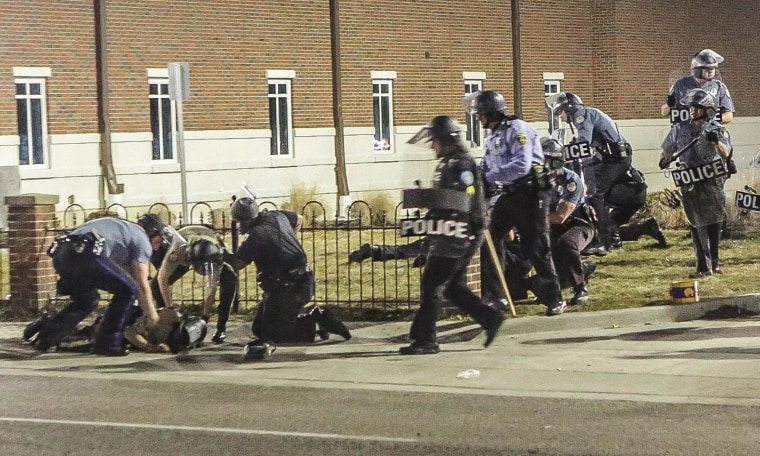 Image: Police officers respond to a fellow officer hit by gunfire outside the Ferguson Police Headquarters in Ferguson