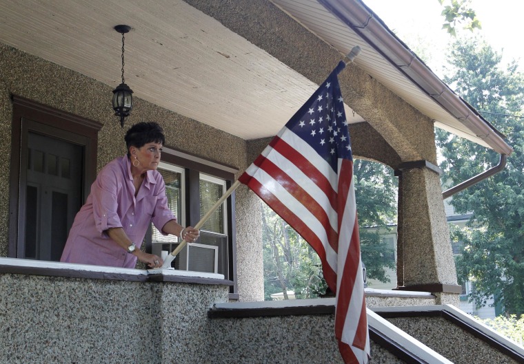 Image: Mary Kay Coyne unfurls a U.S. flag