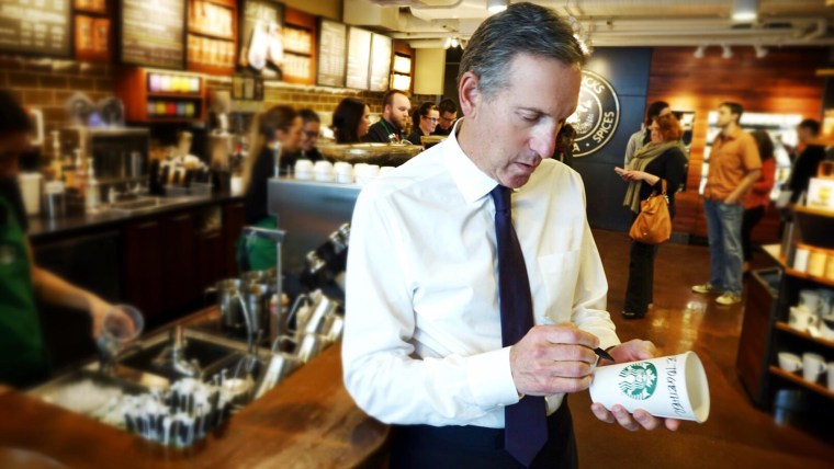 Starbucks CEO Howard Shultz writes "Race Together" on a cup in this publicity photo.