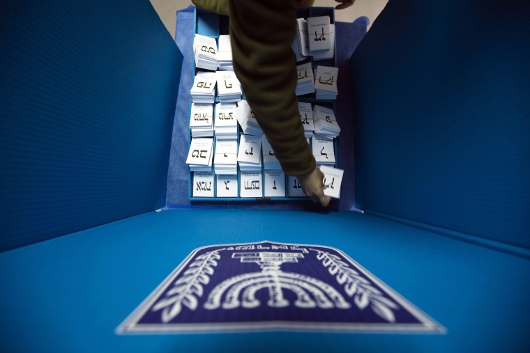 Image: Israeli soldier arranges ballots in a mobile voting booth at a border police base near Nablus