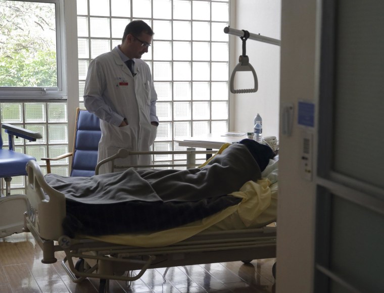 Image: Doctor Stephane Mercier visits a patient at the palliative care unit of the AP-HP Paul-Brousse hospital in Villejuif near Paris