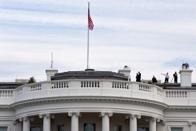 Image: Uniformed Secret Service agents patrol the top of the White House as seen from the South Lawn of the White House in Washington