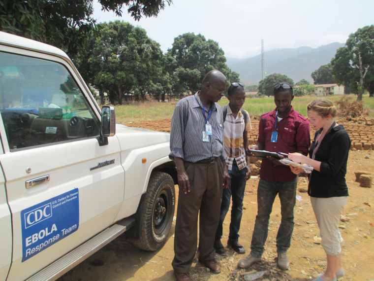 Beth Ervin, a CDC epidemiologist, talks with Ebola surveillance officers: Tomeh Bangura, Ebola Surveillance Officer, Chernoh Yayah Jagitay, Ebola District Surveillance Officer and Abu Bakarr Sesay, Ebola District Surveillance Officer near Freetown, Sierra Leone.