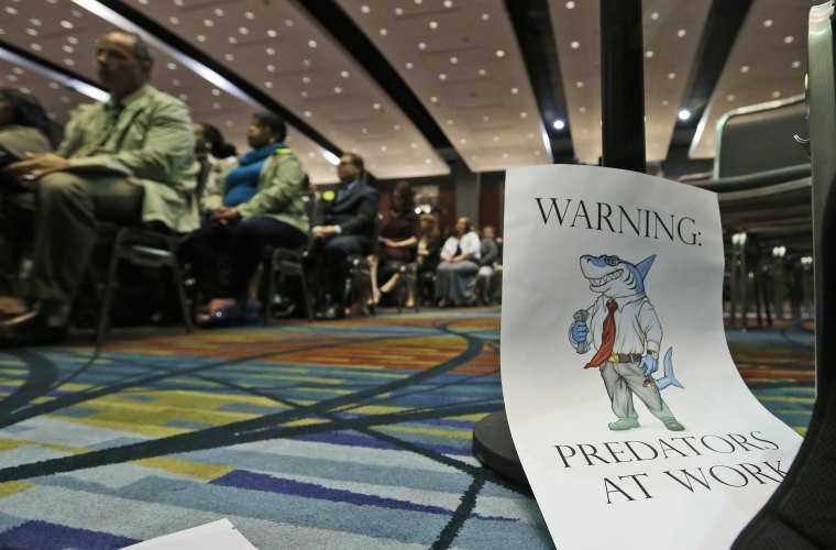 A sign warning of predatory payday lenders leans up against a chair during a speech by Consumer Financial Protection Bureau Director Richard Cordray, in Richmond, Va., Thursday, March 26, 2015.
