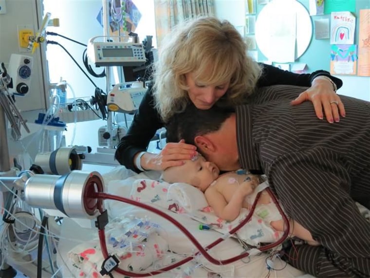 Wendy and Chad Larson share a quiet moment with their 4-month-old daughter Katelyn just before her heart-transplant surgery. "She was just smiling and cooing. It was amazing…. It was just like, ‘Mom, dad, I’m OK.’ It just gave us so much peace knowing that she felt good that morning," her mom said.