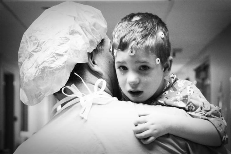 Lane, a 3-year-old neurosurgery patient, cries as a nurse carries him into the operating room.