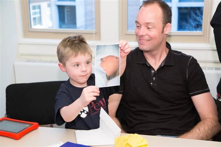 Callum Gray shows researchers a photo of his late twin brother Thomas at the Genetic Diagnostic Laboratory in the department of genetics, at the Perelman School of Medicine, University of Pennsylvania.