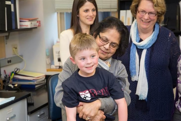 Arupa Ganguly, a professor of genetics at the Hospital of the University of Pennsylvania, holds Callum Gray.