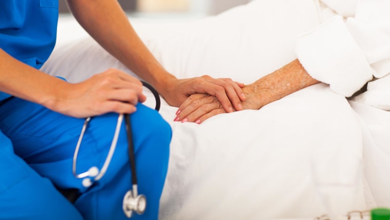 Image: Doctor holding patient's hands.