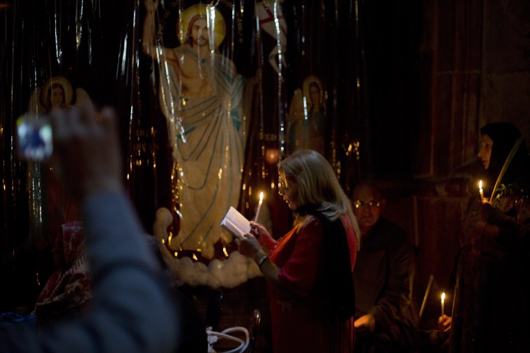 Christian worshipers pray in the Church of the Holy Sepulcher, traditionally believed by many to be the site of the crucifixion and burial of Jesus Christ, during Orthodox Palm Sunday, in Jerusalem, Sunday, April 5, 2015.